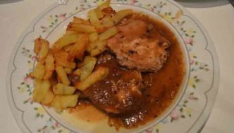 Redondo de lomo de cerdo en salsa de cebolla con patatas fritas