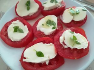 ensalada caprese con rodajas de tomate y mozzarela con albahaca