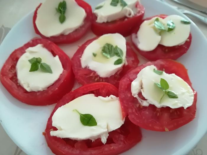 rodajas de tomate y mozzarela con albahaca