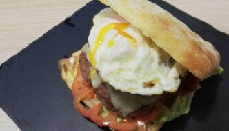 Bocata de hamburguesa con tomate lechuga queso cebolla queso bacon y huevo frito