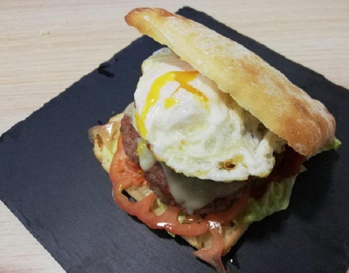 Bocata de hamburguesa con tomate lechuga queso cebolla queso bacon y huevo frito