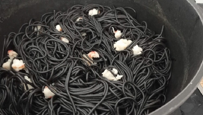 Mezcla el sofrito de gambas con los espaguetis negros