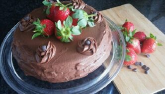 tarta de chocolate con trufa decorada con fresas y pepitas de chocolate